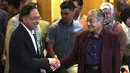 Perdana Menteri Malaysia Mahathir Mohamad (kanan) berjabat tangan dengan Anwar Ibrahim di Putrajaya, Malaysia, Sabtu (22/2/2020). Sebelumnya, Mahathir telah berjanji akan menyerahkan jabatannya kepada Anwar Ibrahim. (AP Photo/Vincent Thian)