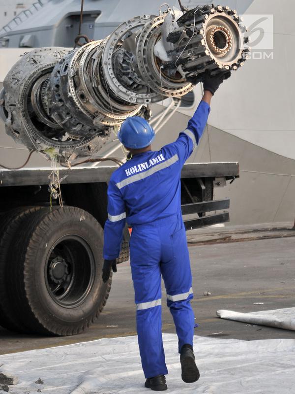 Petugas dibantu alat berat truk mengangkat mesin turbin pesawat Lion Air PK-LQP JT610 di posko evakuasi JICT 2, Tanjung Priok, Jakarta, Minggu (4/11). Mesin tersebut ditemukan di perairan Tanjung Karawang. (merdeka.com/Iqbal S. Nugroho)