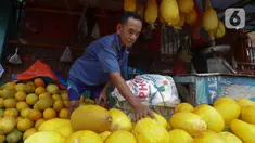 Pedagang menata buah timun suri di Pasar Palmerah, Jakarta, Kamis (6/3/2025). (Liputan6.com/Herman Zakharia)