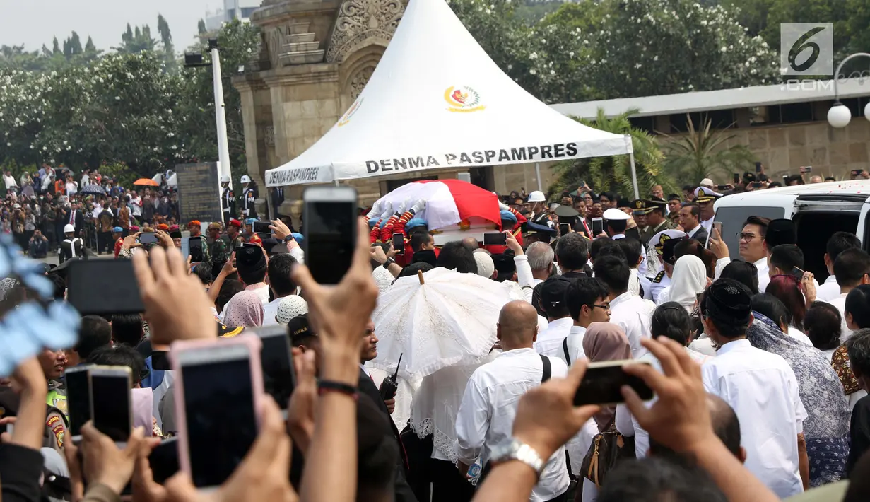Warga berdesakan melihat prosesi pemakaman Presiden ke-3 RI BJ Habibie di TMP Kalibata, Jakarta, Kamis (12/9/2019). Proses pemakaman Habibie terbuka untuk umum. (Liputan6.com/Helmi Fithriansyah)