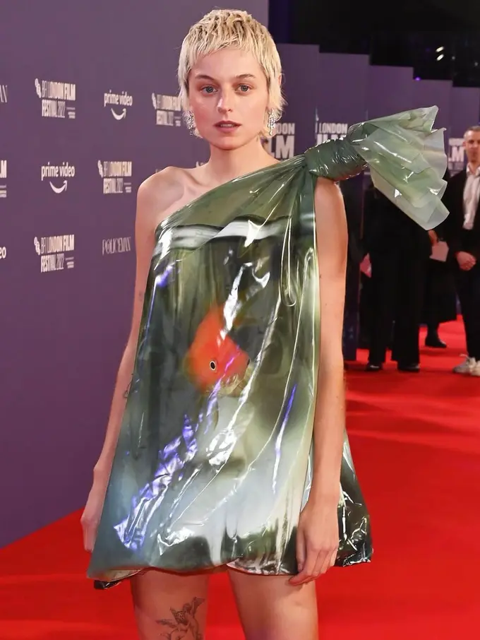 Gaya Nyeleneh Emma Corrin Pakai Gaun Kantong Plastik Berisi Ikan Mas Koki di London Film Festival
