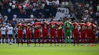Para pemain Preston dan Liverpool mengheningkan cipta selama satu menit untuk mengenang mendiang striker Portugal nomor punggung 20 Liverpool, Diogo Jota, dalam pertandingan persahabatan pramusim antara Preston North End dan Liverpool di Stadion Deepdale, Preston, Inggris barat laut, pada 13 Juli 2025. (Oli SCARFF/AFP)