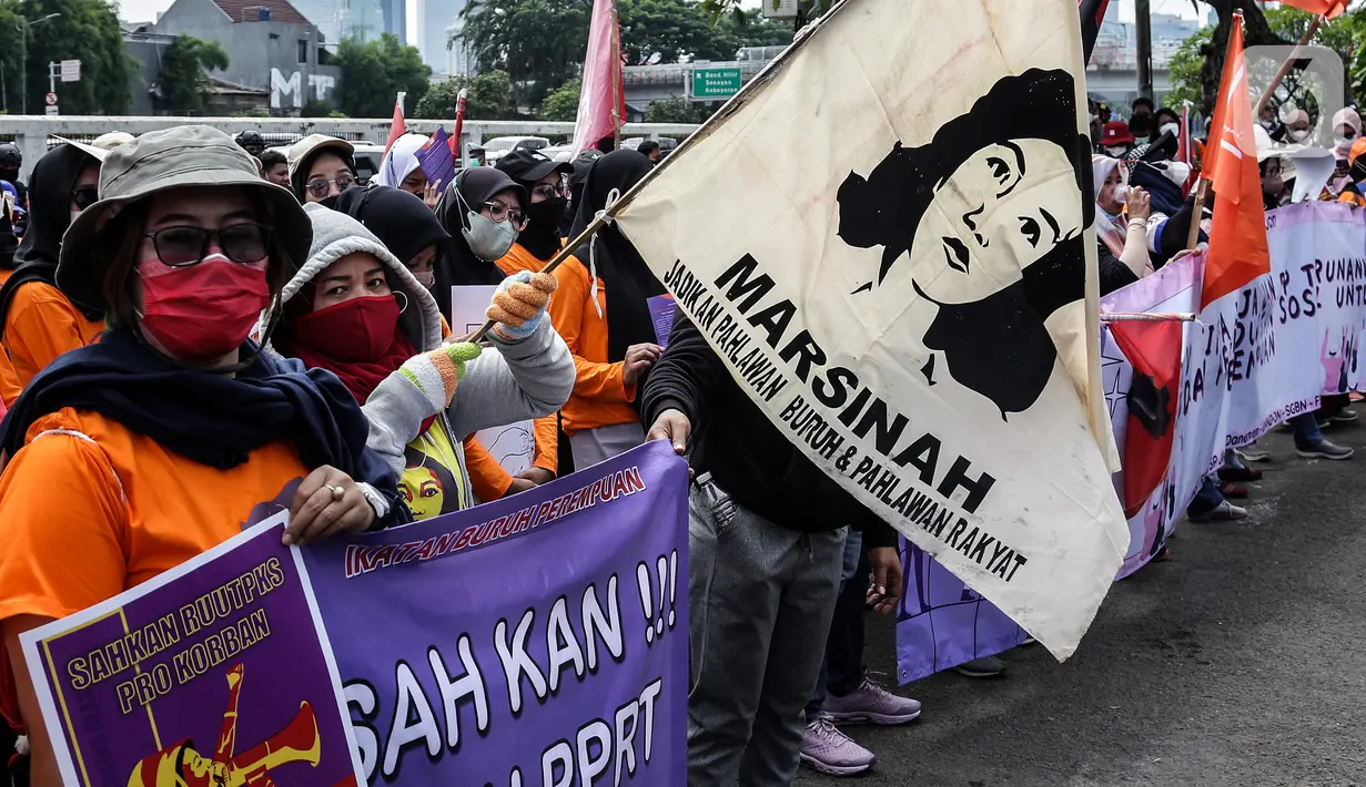 Sejumlah buruh perempuan memegang poster saat menggelar aksi di depan gedung DPR RI, Jakarta, Selasa (8/3/2022). Mereka menuntut dibatalkannya Omnibus Law UU Cipta Kerja dan mendesak agar RUU Tindak Pidana Kekerasan Seksual (TPKS) segera disahkan oleh DPR RI. (Liputan6.com/Johan Tallo)