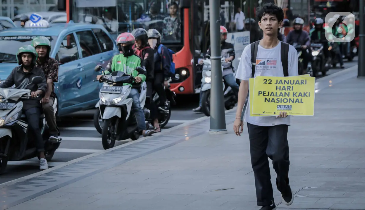 Koalisi Pejalan Kaki berjalan saat menggelar aksi di Trotoar Thamrin, Jakarta, Rabu (22/1/2020). Aksi tersebut dalam rangka memperingati Hari Pejalan Kaki Nasional pada 22  Januari, serta  mengajak pengendara untuk tertib lalu lintas serta menghormati hak pejalan kaki. (Liputan6.com/Faizal Fanani)