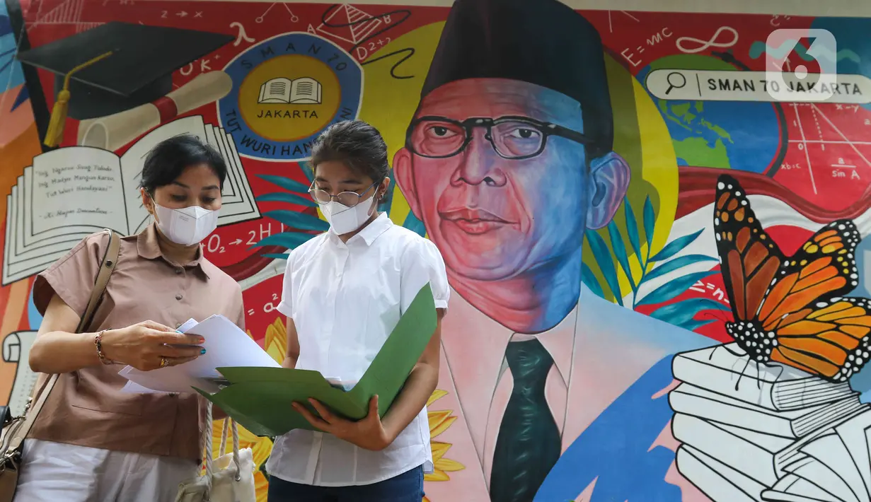 Siswa dan wali murid memeriksa berkas pendaftaran Penerimaan Peserta Didik Baru (PPDB) di Posko Pelayanan PPDB 2022 di SMA Negeri 70, Jakarta, Kamis (19/5/2022). Pemprov DKI Jakarta telah membuka tahapan pra pendaftaran pada proses Penerimaan Peserta Didik Baru (PPDB) 2022 dari jenjang Sekolah Dasar (SD) hingga Sekolah Menengah Atas (SMA). (Liputan6.com/Herman Zakharia)