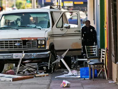 Petugas memeriksa mobil van yang menabrak kerumunan orang di depan sebuah restoran di Los Angeles, Amerika Serikat, Minggu (30/7). Setidaknya sembilan orang luka-luka dalam insiden itu, dengan salah seorang di antaranya kritis (AP Photo/Damian Dovarganes)