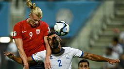 Pemain Norwegia, Erling Haaland (kiri) berduel udara dengan pemain Sipurs, Jewel Samad pada laga Grup A Kualifikasi Euro 2024 di AEK Arena, Sipurs, Jumat (13/10/2023) dini hari WIB. (AFP/Jewel Samad)