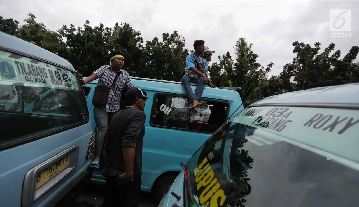 Para pengemudi angkutan memarkirkan mobilnya berkumpul untuk menggelar unjuk rasa di depan Balai Kota, Jakarta, Senin (22/1). (Liputan6.com/Faizal Fanani)