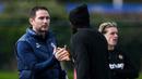 Pelatih Chelsea, Frank Lampard, bersalaman dengan pemain saat sesi latihan jelang laga Liga Champions melawan Real Madrid di London, (11/4/2023). Optimisme tinggi diapungkan manajer Chelsea, Frank Lampard menjelang pertemuan kontra Real Madrid. (AFP/Daniel Leal)