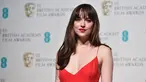 Aktris AS, Dakota Johnson ketika menghadiri ajang penghargaan British Academy of Film and Television Arts (BAFTA) 2016 di London, Minggu (14/2). Nominator kategori Rising Star itu tampil dalam balutan gaun merah berbelahan dada rendah. (AFP/Ben STANSALL)