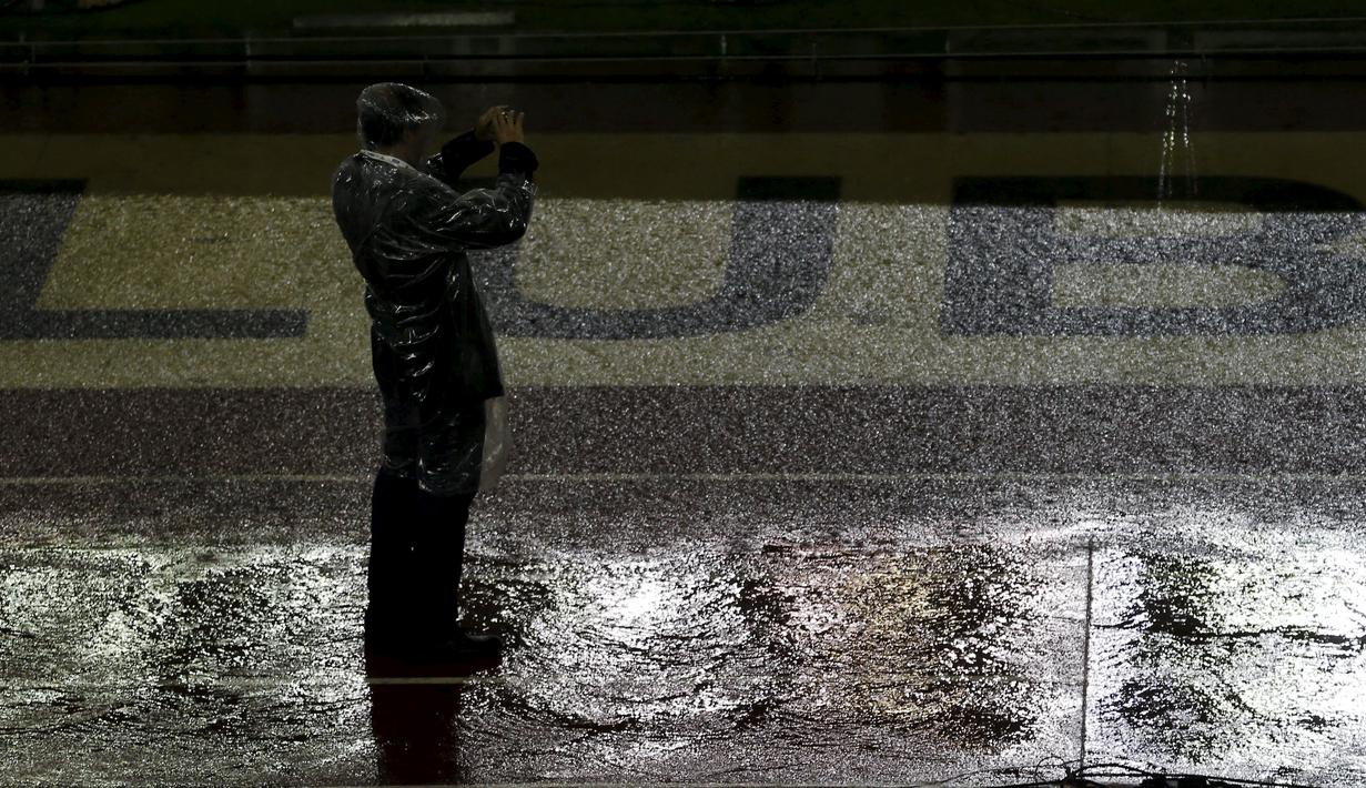 Seorang petugas mengambil gambar lapangan Stadion Monumental, Buenos Aires, Argentina, yang tergenang sebelum laga Kualifikasi Piala Dunia 2018 antara Argentina melawan Brasil ditunda. Jumat (13/11/2015) WIB. (Reuters/Marcos Brindicci)
