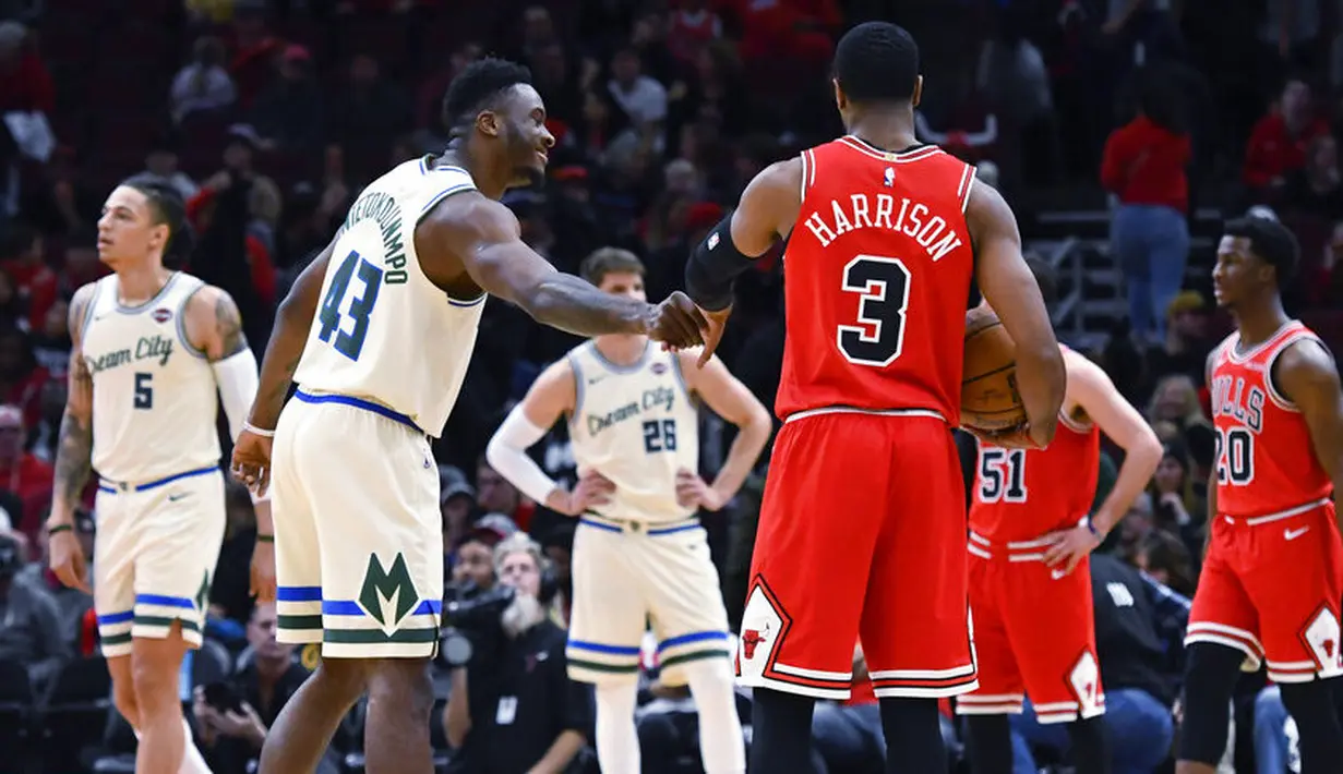 Pebasket Chicago Bulls, Shaquille Harrison, berbincang dengan pebasket Milwaukee Bucks, Thanasis Antetokounmpo, pada laga NBA di United Center, Selasa (31/12/2019). Milwaukee Bucks menang 123-102 atas Chicago Bulls. (AP/Matt Marton)