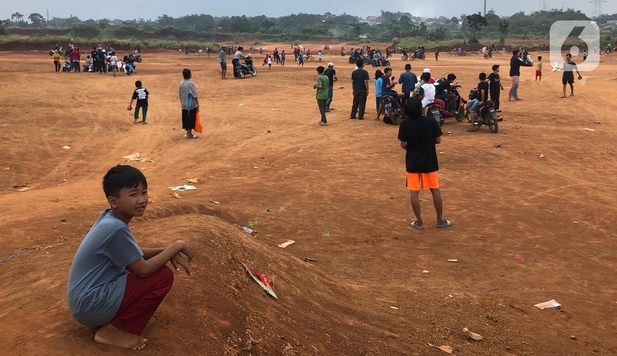 Warga beraktivitas di tanah lapang di kawasan Cipayung, Depok, Jawa Barat, Kamis (11/6/2020). Kurang tegasnya sanksi serta minimnya kesadaran masyarakat akan protokol kesehatan terkait covid-19 menyebabkan kawasan itu menjadi tempat berkerumun warga setiap sore hari. (Liputan6.com/Immanuel Antonius)