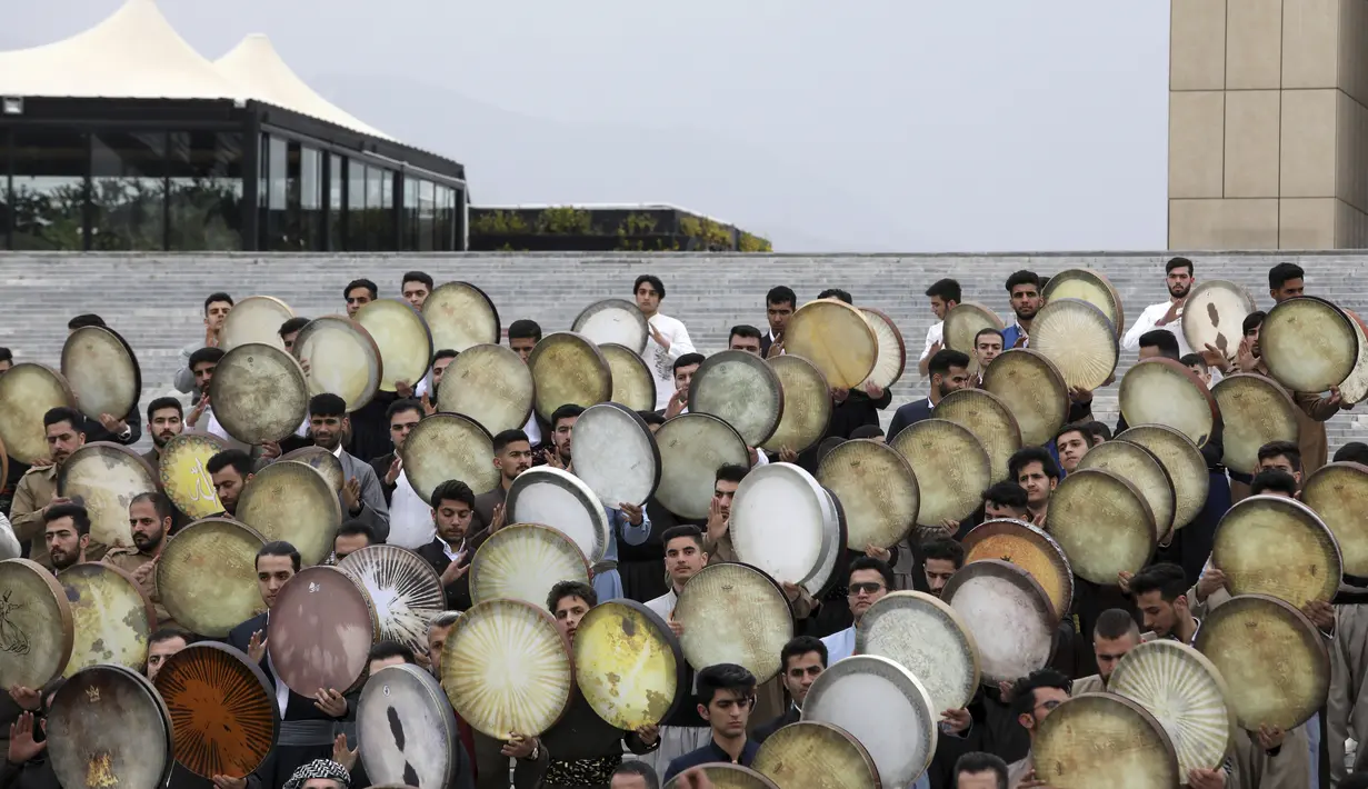 Musisi dari wilayah barat Kurdi Iran memainkan Daf dalam upacara menjelang Tahun Baru Iran, atau Nowruz, di Teheran, Iran (14/3/2022). Nowruz berasal dari setidaknya 1700 SM dan dalam tradisi Zoroaster kuno adalah hari libur paling penting dan diantisipasi dalam budaya Iran. (AP Photo/Vahid Salemi)
