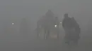 Sejumlah kendaraan melintas saat kabut asap tebal menyelimuti Lahore, Pakistan (3/1). Polusi udara telah menyebar akibat asap kendaraan, situs bangunan dan petani yang membakar tanaman di daerah di luar ibukota India. (AFP Photo/Arif Ali)