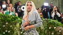 Kim Kardashian memilih kreasi off-the-shoulder dari John Galliano untuk Maison Margiela, dengan tampilan metalik termasuk kardigan kasmir di atas korset perak yang terbuat dari kain brokat antik. (Angela WEISS / AFP)