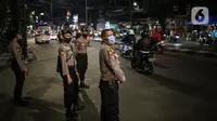 Polisi berjaga pada malam takbiran di Jalan KH Mas Mansyur, Jakarta, Sabtu (23/5/2020). Polisi dikerahkan menjaga Jalan KH Mas Mansyur untuk mengantisipasi adanya takbir keliling di kawasan tersebut. (Liputan6.com/Faiza Fanani)