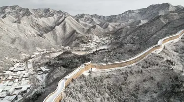 Foto ini menunjukkan pemandangan udara dari bagian Tembok Besar Cina yang tertutup salju di Shuiguan, sebelah utara Beijing, pada 15 Desember 2023. (GREG BAKER/AFP)
