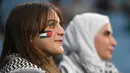 Seorang pendukung mengenakan cat wajah terlihat sebelum dimulainya pertandingan sepak bola Grup C Piala Asia AFC Qatar 2023 antara Palestina dan Uni Emirat Arab di Stadion Al-Janoub di Al-Wakrah, Doha pada 18 Januari 2024. (HECTOR RETAMAL/AFP)