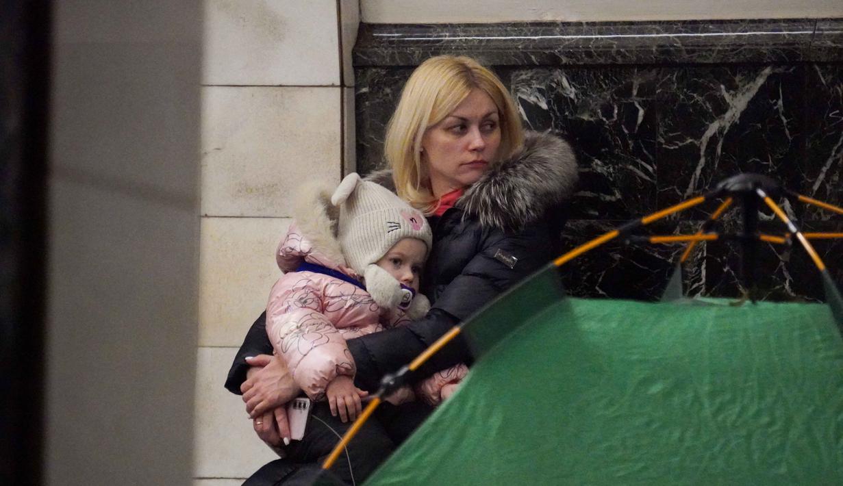 Sebelumnya, di tengah cuaca dingin ekstrem yang melanda Ukraina, Rusia kembali melancarkan serangan besar-besaran pada Selasa (3/2/2026). Tampak dalam foto, seorang wanita dan seorang anak berlindung di stasiun metro selama serangan udara Rusia di Kyiv, pada Selasa 3 Februari 2026 pagi waktu setempat. (Serhii Okunev/AFP)