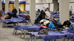 Pengungsi duduk di tempat tidur di pusat pengungsi yang tiba dari Ukraina di Messe di Berlin, Jerman pada 11 Maret 2022. Badan PBB untuk urusan pengungsi (UNHCR) mengatakan setidaknya 2,5 juta orang telah meninggalkan Ukraina, dengan lebih dari setengahnya sekarang di Polandia. (Odd ANDERSEN / AFP)