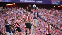 Mikel Merino (Arsenal) dan Andoni Gorosabel (Athletic Bilbao) melompat berebut bola dalam laga pembuka Liga Champions di San Mames, Spanyol, 16 September 2025. (AP Photo/Miguel Oses)