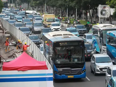 Pekerja menyelesaikan proyek revitalisasi di salah satu halte Transjakarta kawasan Karet, Jakarta, Rabu (7/6/2023). (Liputan6.com/Johan Tallo)