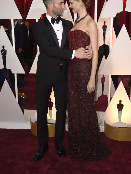 Penyanyi Adam Levine dan model Behati Prinsloo menghadiri Academy Awards Tahunan ke-87 di Hollywood & Highland Center di Hollywood, California pada 22 Februari 2015. Isu perselingkuhan Adam Levine terkuak saat influencer media sosial Sumner Stroh menyebarkan berbagai bukti mencengangkan. (Frazer Harrison/Getty Images/AFP)