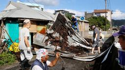Topan Haishen di Jepang: Warga memperbaiki atap yang rusak akibat angin kencang menyusul topan Haishen di Amami, prefektur Kagoshima, barat daya Jepang, Senin (7/9/2020). Topan kuat kedua yang melanda wilayah itu dalam sepekan ini menyebabkan korban terluka dan bangunan rusak. (Kyodo News via AP)