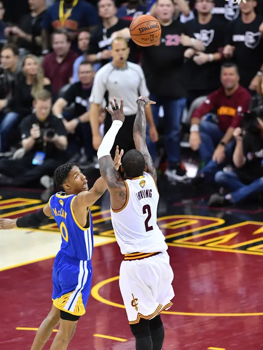 Pemain Cavaliers, Kyrie Irving berusaha menembak bola dari penjagaan pemain Warriors, Patrick McCaw pada gim keempat Final NBA 2017 di Quicken Loans Arena, Ohio (9/6). Cavaliers menghajar Golden State Warriors 137-116. (Jason Miller/Getty Images/AFP)