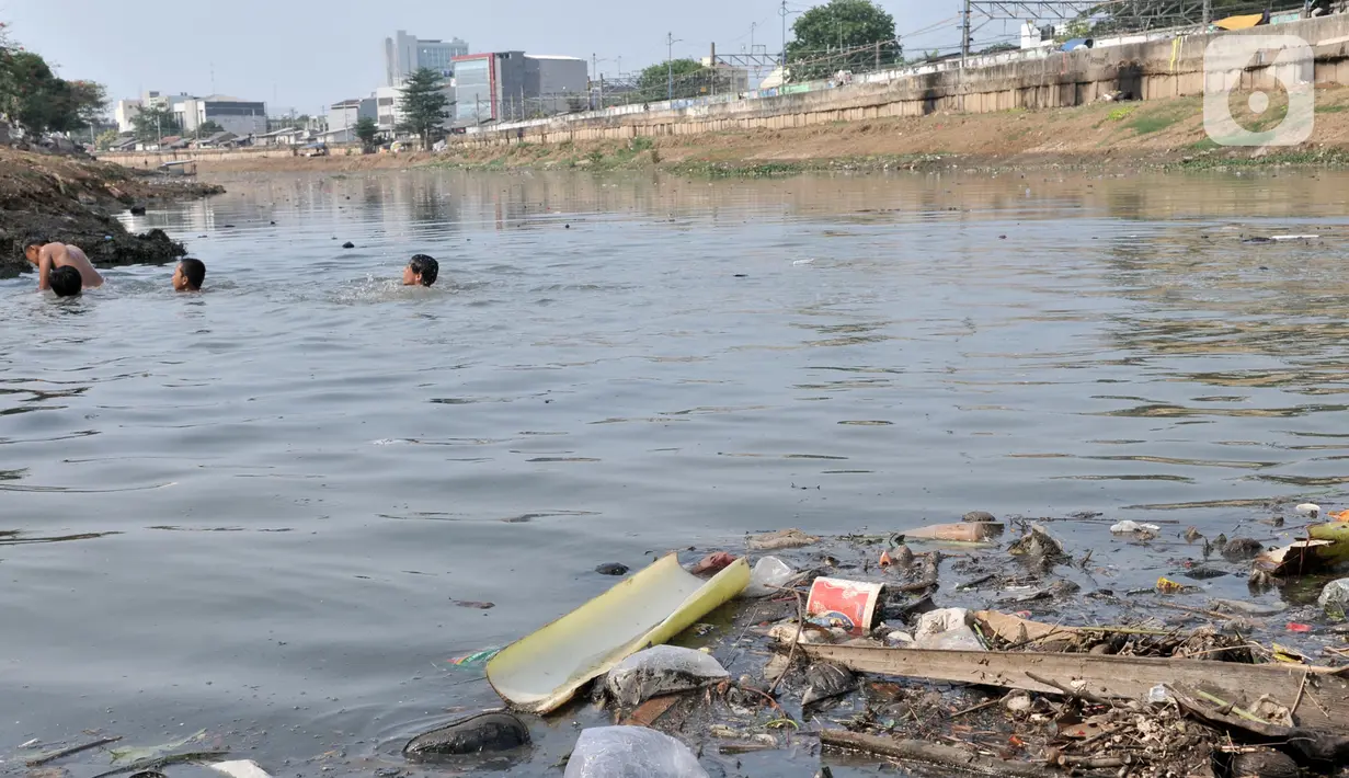 Anak-anak berenang di Kanal Banjir Barat, Jakarta, Minggu (3/11/2019). Mereka memilih berenang di Kanal Banjir Barat karena minimnya fasilitas bermain di kawasan tersebut. (merdeka.com/Iqbal Nugroho)