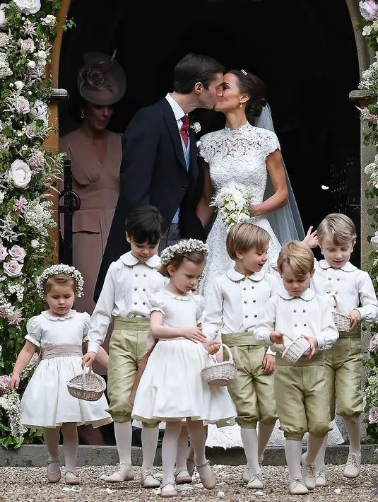 Pippa Middleton dan James Matthews berciuman setelah resmi menikah di sebuah gereja kecil di Inggris, Sabtu (20/5). Pernikahan itu dihadiri sejumlah nama besar seperti Pangeran Harry, Pangeran William dan petenis Roger Federer. (JUSTIN TALLIS/POOL/AFP)