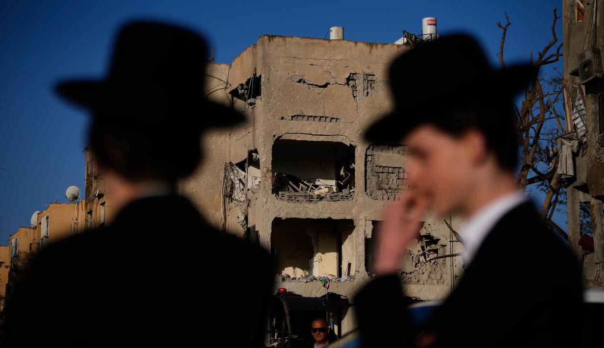 Otoritas Israel Defense Forces (IDF) melalui Komando Pertahanan Dalam Negeri langsung memperketat pedoman keamanan di wilayah selatan Israel. Tampak dalam foto, warga melihat bangunan tempat tinggal yang rusak akibat serangan rudal Iran di Arad, Israel Selatan, Minggu, 22 Maret 2026. (AP Photo/Ohad Zwigenberg)