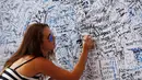 Meski telah penuh dengan tulisan dan tanda tangan, keinginan untuk ikut serta memberikan tulisan empati terus berdatangan (REUTERS/Edgar Su)