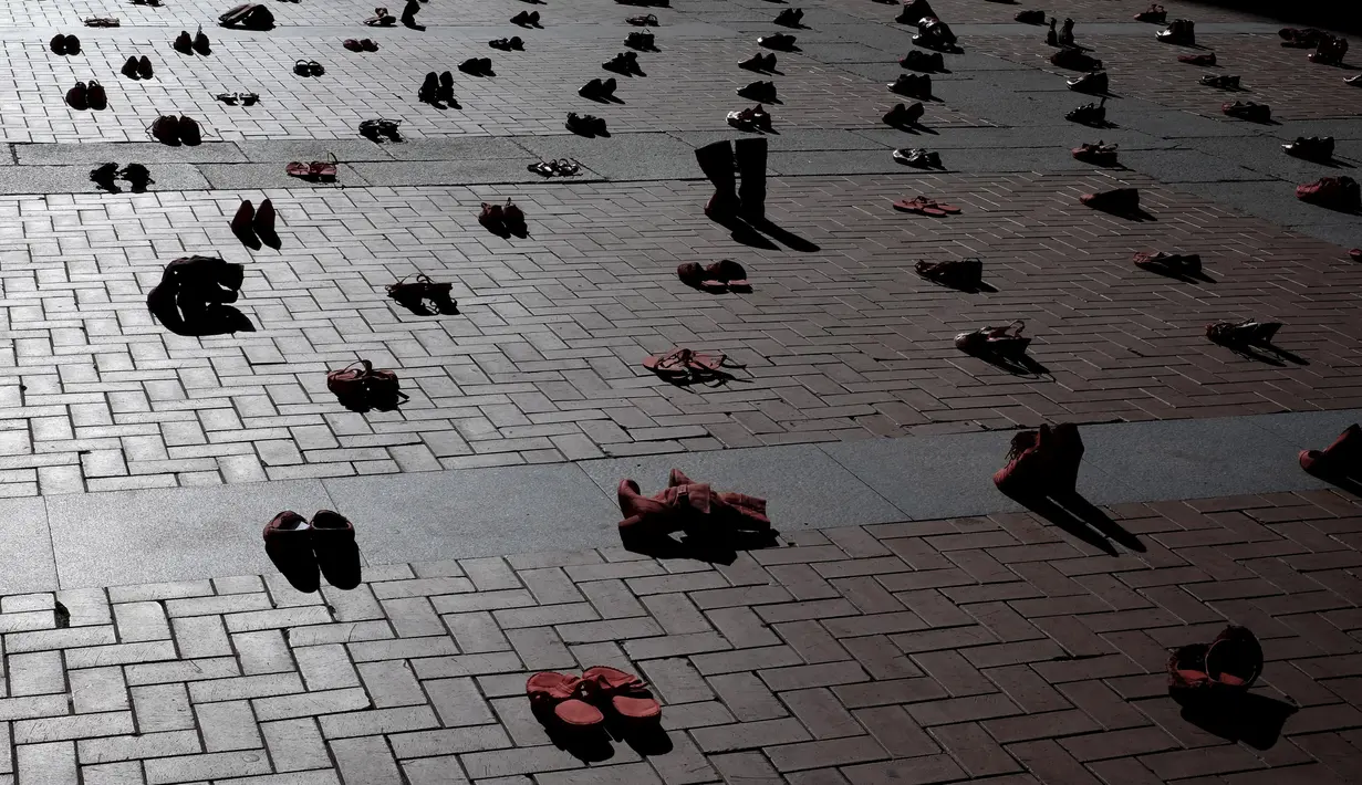 Puluhan sepatu merah terlihat ditempat di Plaza Mayor sebagai tanda untuk memperingati Hari Internasional untuk Penghapusan Kekerasan terhadap Perempuan di Valladolid, Spanyol, Rabu (25/11). (REUTERS/ Juan Medina)