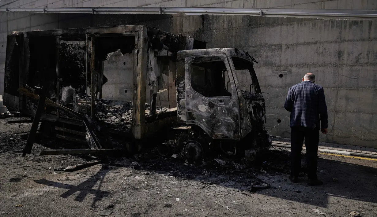 Penyerangan tersebut mengakibatkan cedera, penangkapan, serta kerusakan material yang luas. Tampak dalam foto, warga Palestina memeriksa kendaraan yang terbakar setelah serangan yang dilakukan oleh pemukim Israel pada hari sebelumnya di kawasan industri di desa Beit Lid, Tepi Barat, dekat Tulkarm, Rabu 12 November 2025. (AP Photo/Majdi Mohammed)
