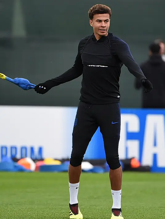 Gelandang Inggris, Dele Alli memegang mainan ayam selama mengikuti sesi latihan di Repino, Rusia (10/7). Inggris akan bertanding melawan Kroasia pada babak semifinal Piala Dunia 2018. (AFP Photo/Ellis)