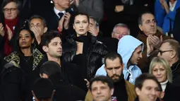 Model AS Bella Hadid menonton PSG melawan Real Madrid dalam pertandingan Liga Champions leg kedua di stadion Parc des Princes di Paris di (6/3). Pertandingan ini dimenangkan Madrid dengan skor 2-1 atas PSG. (AFP Photo/Franck Fife)