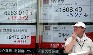 Seorang pria berdiri didepan indikator saham elektronik sebuah perusahaan sekuritas di Tokyo (29/8). Ketegangan politik yang terjadi karena Korut meluncurkan rudalnya mempengaruhi pasar saham Asia. (AP Photo/Shizuo Kambayashi)