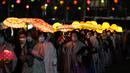 Umat Buddha Korea Selatan mengenakan masker membawa lentera lotus berwarna-warni selama upacara pencahayaan untuk merayakan ulang tahun Buddha yang akan datang pada 8 Mei, di Seoul, Korea Selatan (5/4/2022). (AP Photo/Lee Jin-man)