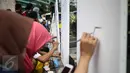 Pengunjung mengikuti aksi melukis di kanvas disela kegiatan Car free Day (CFD) di kawasan Bundaran HI, Jakarta, Minggu (12/2). Aksi yang digelar oleh Greenpeace itu untuk mengenalkan masyarakat tentang sadar polusi. (Liputan6.com/Faizal Fanani)