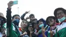 Para buruh berselfie disela aksi  unjuk rasa di kawasan Patung Kuda, Jakarta, Selasa (1/8/2015). Mereka menuntut pemerintah menghentikan gelombang PHK yang mengancam akibat melemahnya nilai tukar rupiah terhadap dolar. (Liputan6.com/Gempur M Surya)
