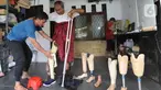 Ortotis prostetis atau pembuat kaki tangan palsu memasangkan kaki palsu buatannya kepada penyandang disabilitas di sebuah bengkel kawasan Ciputat Baru, Tangerang Selatan, Banten, Senin (14/10/2019). Kaki dan tangan palsu dijual dengan harga Rp 5 juta hingga Rp 50 juta. (merdeka.com/Arie Basuki)