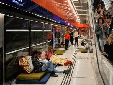 Orang-orang berlindung di stasiun metro bawah tanah saat sirene serangan udara memperingatkan datangnya rudal Iran di Tel Aviv, Israel, Sabtu, 7 Maret 2026. Sirene serangan udara di Tel Aviv, Israel, kembali meraung menyusul gelombang baru serangan rudal dari Iran. (AP Photo/Ohad Zwigenberg)