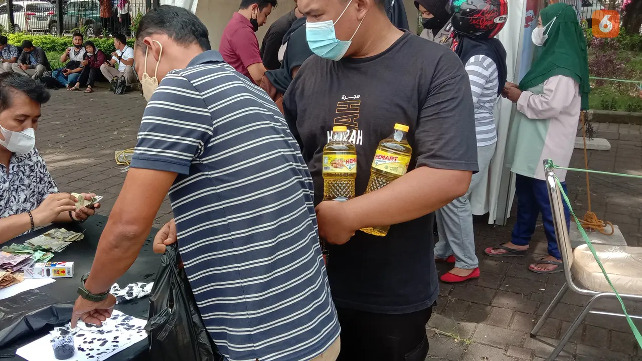 Warga Yang Sudah Dapakan Minyak Goreng, Menyelupkan Jari Ke Tinta. (Rabu, 09/03/2022). (Liputan6.com/Yandhi Deslatama).