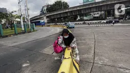 Warga melewati pembatas jalan di kawasan Blok-M, Jakarta, Senin (14/3/2022). Menurut Jubir Pemerintah untuk Penanganan COVID-19 Reisa Broto Asmoro, peralihan pandemi ke endemi tak bisa lepas dari jumlah kasus harian dan angka kematian rendah serta tingkat keterisian RS. (Liputan6.com/Johan Tallo)