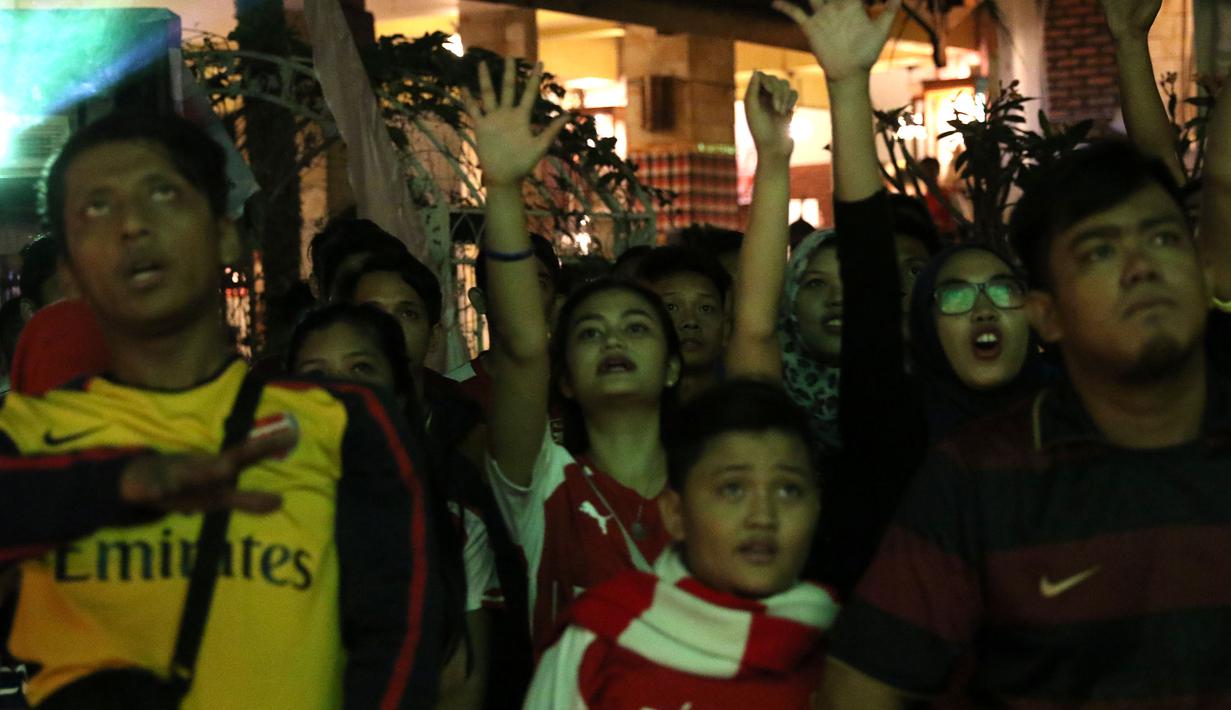 Suporter yang tergabung dalam Arsenal Indonesia Supporters (AIS) memeriahkan acara nonton bareng Liga Premier Inggris antara Newcastle United melawan Arsenal di Gumati Cafe, Bogor. Sabtu (29/8/2015). (Bola.com/Arief Bagus)