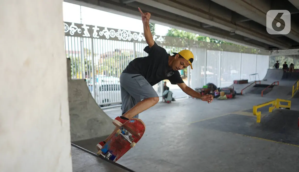 Seorang warga bermain skate board di fasilitas skate park kolong flyover Pasar Rebo, Jakarta, Selasa (14/1/2020). Skate park yang telah selesai dibangun tersebut kini mulai diramaikan pengunjung, khususnya pada sore hari. (Liputan6.com/Immanuel Antonius)