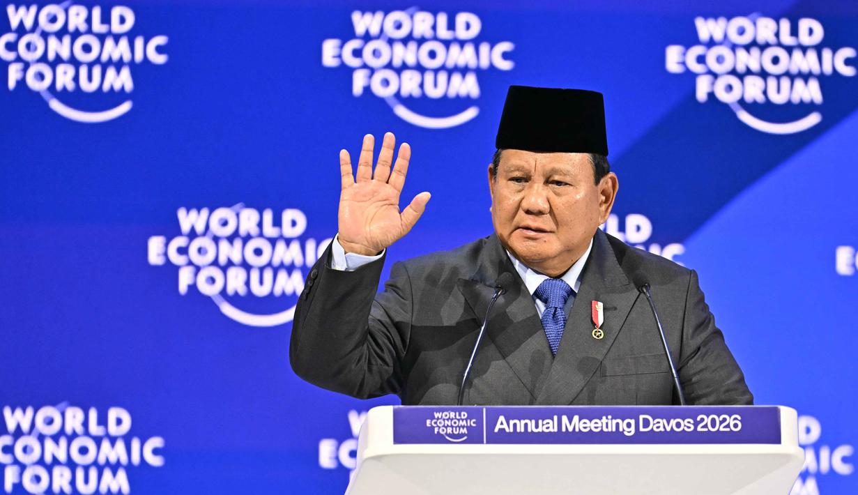 Hal itu dipaparkan Presiden Prabowo saat berpidato pada pertemuan tahunan Forum Ekonomi Dunia (WEF) di Davos, Swiss, pada Kamis 22 Januari 2026. Tampak dalam foto, Presiden Indonesia, Prabowo Subianto mengangkat tangan saat menyampaikan pidato khusus (special address) pada pertemuan tahunan Forum Ekonomi Dunia (WEF) di Davos, Swiss, pada Kamis 22 Januari 2026. (Fabrice COFFRINI/AFP)