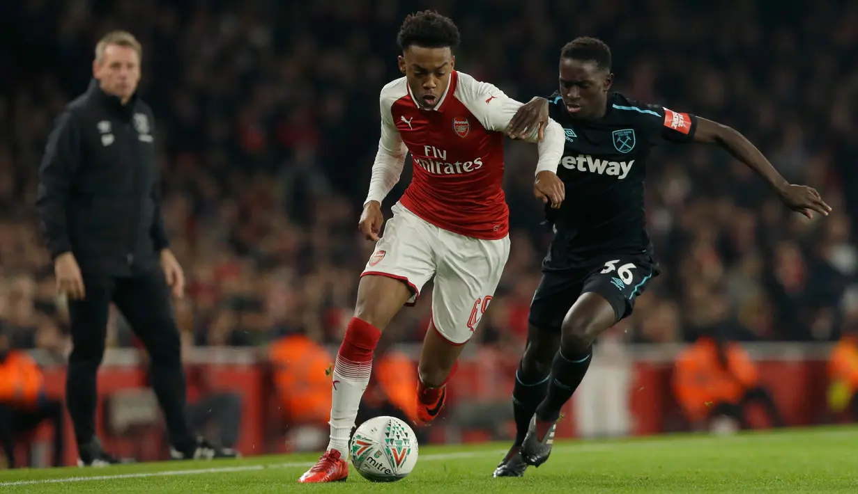 Pemain Arsenal, Joe Willock berebut bola dengan pemain West Ham United, Domingos Quina pada laga perempat final Piala Liga Inggris di Emirates Stadium, Selasa (20/12). Gol tunggal Danny Welbeck memberikan Arsenal kemenangan 1-0. (AP /Alastair Grant)